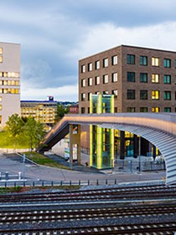 Campus Heilbronn with lighted buildings and rails in the foreground
