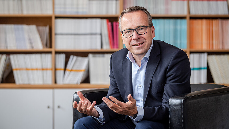 Headshot of dean prof gunther-friedl, a middle age man smiling on a simple background.