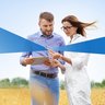 One male and female student in a grain field with tablet