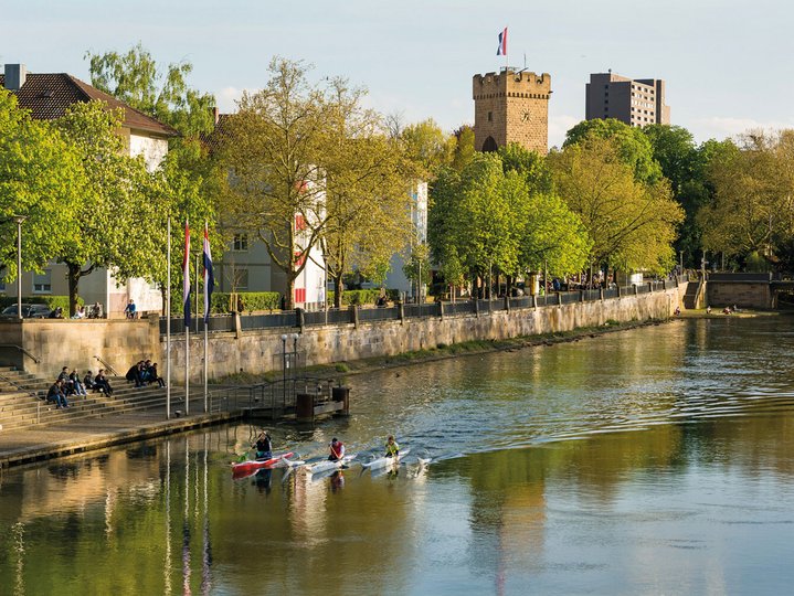 View of the Neckar and the Götzenturm in Heilbronn. People kayaking on the Neckar river. 